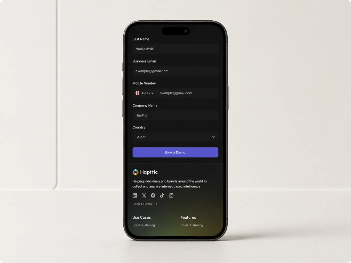 Hapttic demo booking form and website footer displayed on a phone
